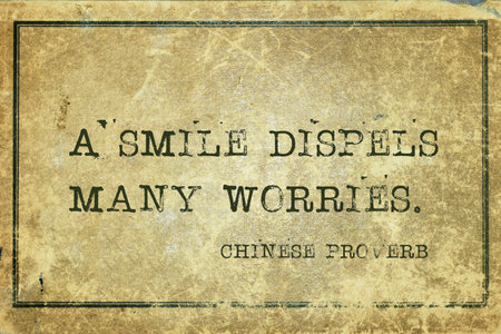 A smile dispels many worries - ancient Chinese proverb printed on grunge vintage cardboardの写真素材