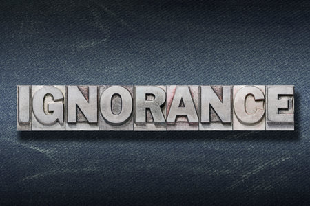 ignorance word made from metallic letterpress on dark jeans backgroundの写真素材