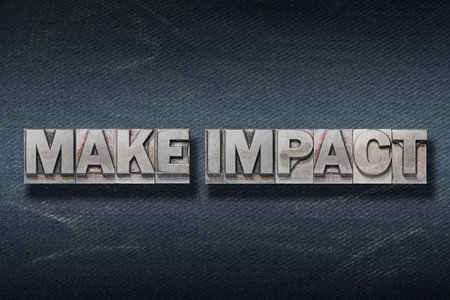 make impact phrase made from metallic letterpress on dark jeans backgroundの写真素材