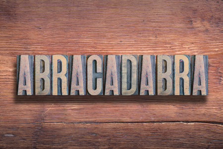 abracadabra word meaning incantationÂ used as aÂ magic word, combined on vintage varnished wooden surfaceの写真素材