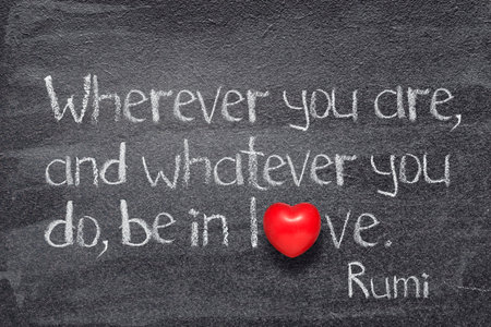 Wherever you are, and whatever you do, be in love -  ancient Persian poet and philosopher Rumi quote written on chalkboard with red heart symbol instead of Oの写真素材
