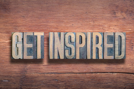 get inspired phrase combined on vintage varnished wooden surface