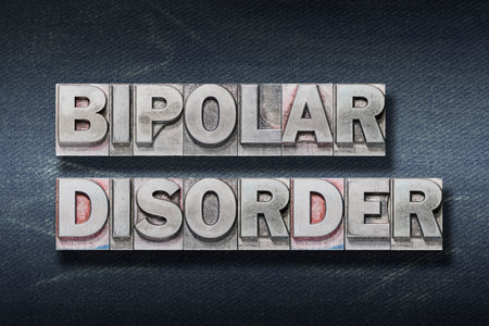bipolar disorder phrase made from metallic letterpress on dark jeans backgroundの写真素材