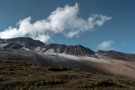 altitude Peruvian Andes landscape with black rocky ridge under blue cloudy skyの写真素材