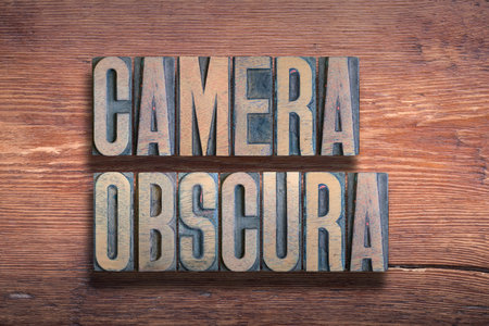 camera obscura ancient Latin phrase meaning dark chamber, combined on vintage varnished wooden surfaceの写真素材