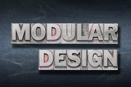 modular design phrase made from metallic letterpress on dark jeans background