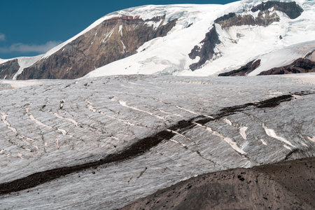 glacier field with distant rocky mountain ridge by sunny day near Elbrus mountain, Russiaの写真素材