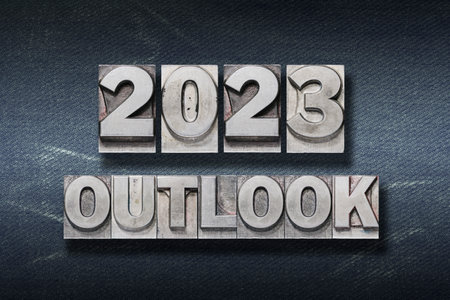 outlook 2023 phrase made from metallic letterpress on dark jeans backgroundの写真素材