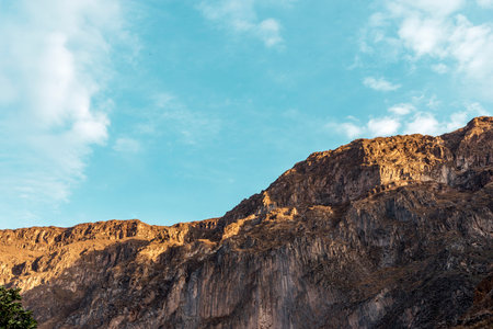 huge rocky cliff under blue bright sky in Peruの写真素材