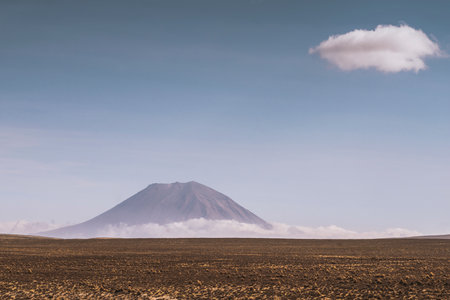scenic landscape with Misti volcano and single white cloud on altitude in Peru