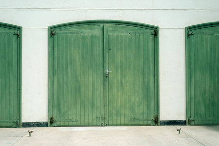 big green wooden doors of old garage buildingの写真素材