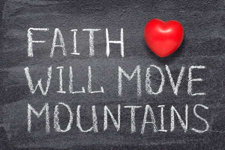 faith will move mountains proverb written on chalkboard with red heart symbol