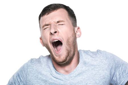 Tired sleepy young man yawningの写真素材