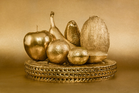 Set of fruits with golden peel on gold backgroundの写真素材