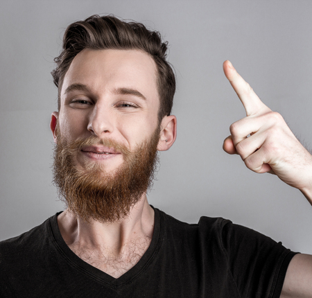 Exited young man isolated on gray background. Emotional portraitの写真素材