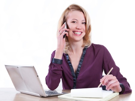 Business woman working on a laptop - isolated over whiteの写真素材