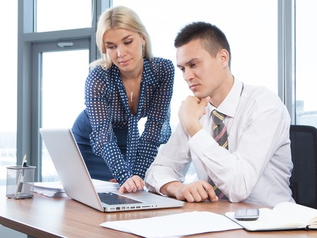 Business people working together on laptop in office at deskの写真素材