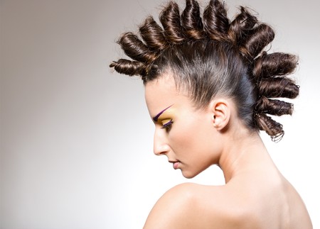 studio portrait of young beautiful brunette with creative makeup and hairstyle