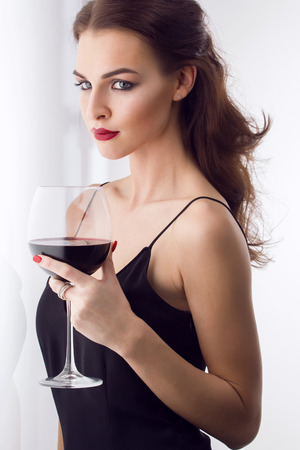 young gorgeous brunette with glass of red wineの写真素材