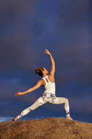young caucasian fitness woman practicing yoga outdoorsの写真素材