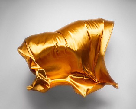 abstract piece of yellow fabric flying, high-speed studio shotの写真素材