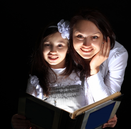 Girl with my mother found a wonderful book.の写真素材