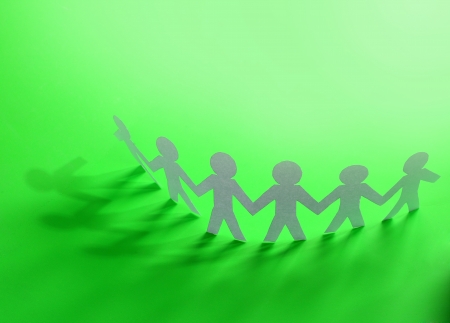 Team of paper doll people holding hands の写真素材