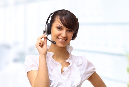 Beautiful business woman operator, in the headphones in the office.の写真素材