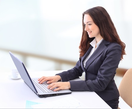 Thoughtful business woman in the office for a laptop with a smile.の写真素材