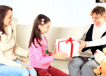Little beautiful pretty girl giving a gift to her happy motherの写真素材