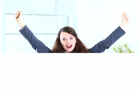Nice business woman in the office of the shows poster, hands up.の写真素材