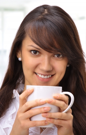 Beautiful businesswoman drinking coffee in the office.の写真素材