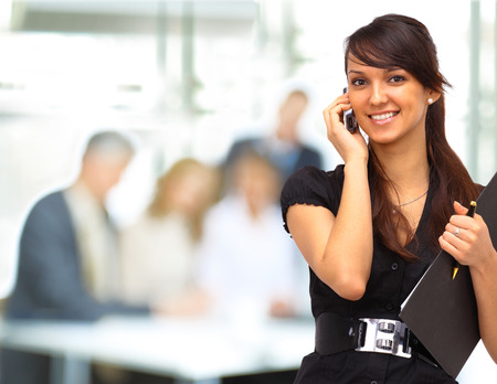 confident business woman with team behind her の写真素材