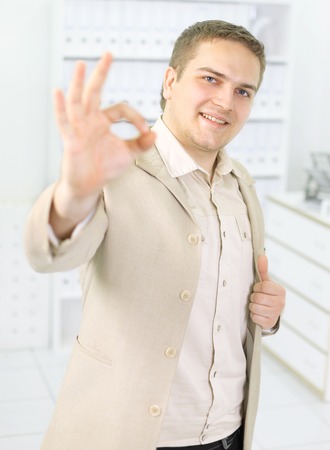 Happy businessman with okay gesture, isolated on white の写真素材