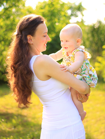 Beautiful Mother And Baby outdoors. Nature. Beauty Mum and her Child playing in Park togetherの写真素材