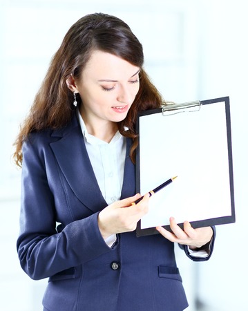 Portrait of a cute young business woman with the work plan smiling.の写真素材