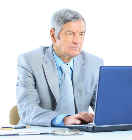 The businessman at the age of works for the laptop. Isolated on a white background.の写真素材