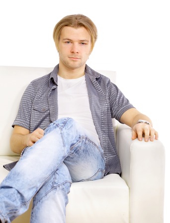 Portrait of the young man in white on sofa の写真素材