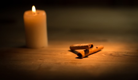 Cinnamon sticks on wood table with bundles of cinnamon in soft focus in background. の写真素材