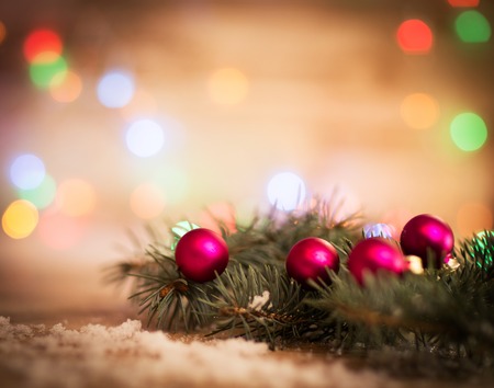 Closeup of a red Christmas balls and fir-tree branches on wooden background.の写真素材