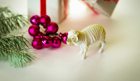 toy lamb with Christmas balls and fir paws giftsの写真素材