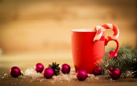 Christmas mug with decorations and sweets on wooden backgroundの写真素材