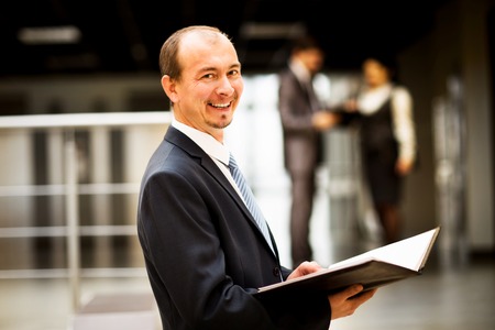 Happy smart business man with team mates discussing in the backgroundの写真素材