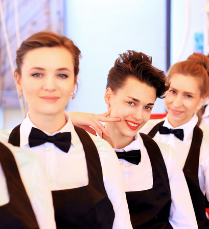 Large group of waiters and waitresses standing in row.の写真素材