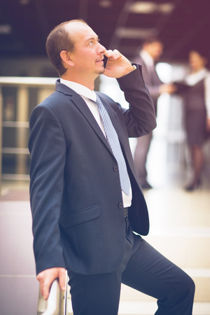 business man talking on cell phone at modern officeの写真素材