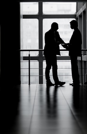 contour businessmen diskussiya in the office in front of the windowの写真素材