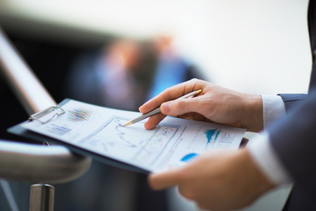 Close-up of female and male hands pointing at business document while discussing it