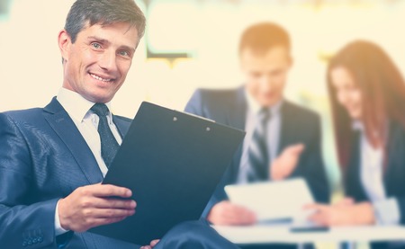 Portrait of a successful businessman in the office on the background  working business team in  modernの写真素材