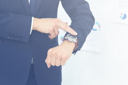 idea is to save time. businessman pointing at his wristwatchの写真素材