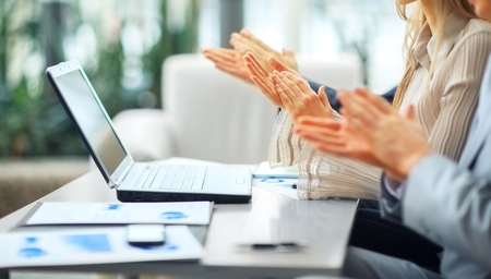 Close-up of business people clapping hands.